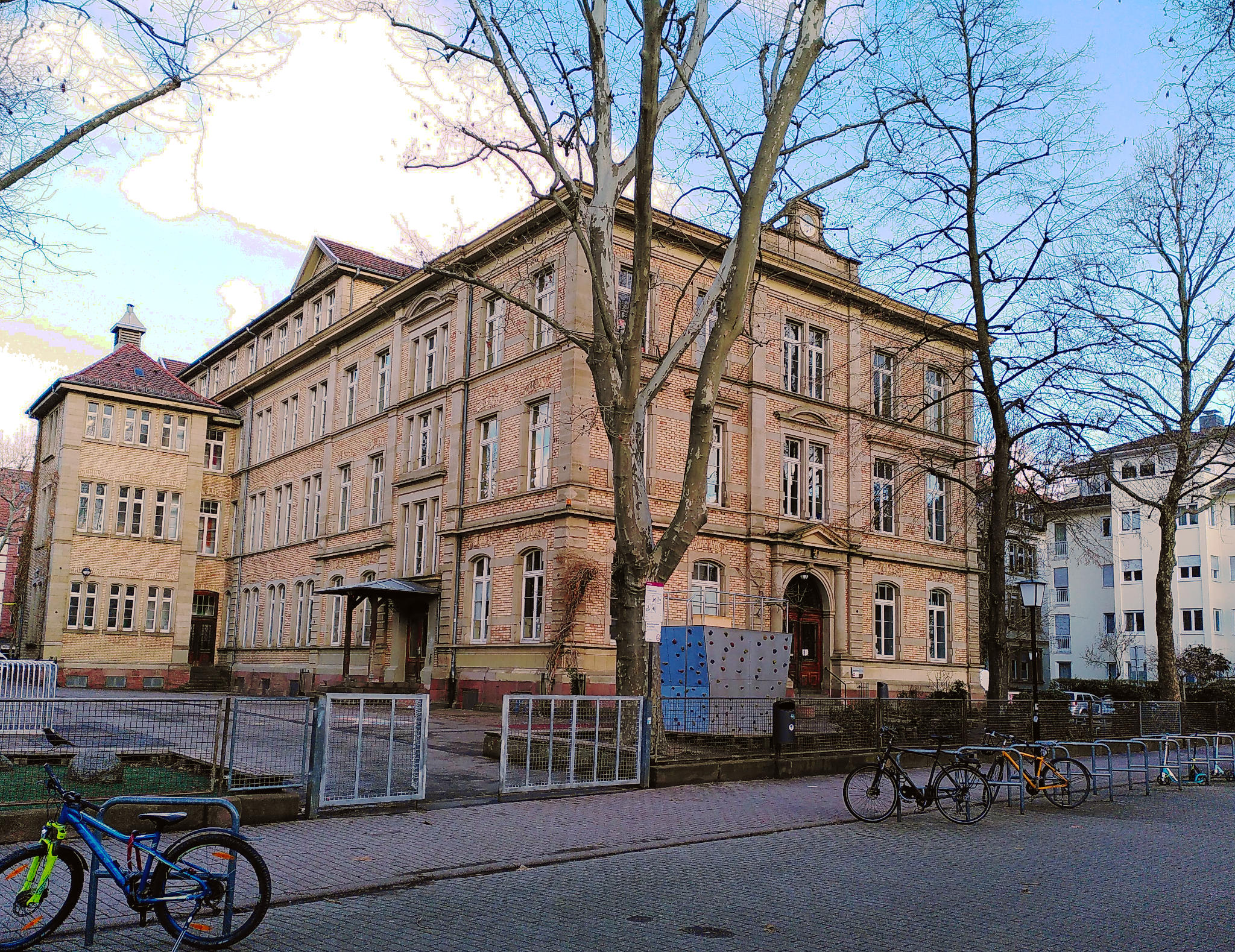 Schulhof und Schulgebäude der Landhausschule. Das Gebäude besteht aus hellen Backsteinen.