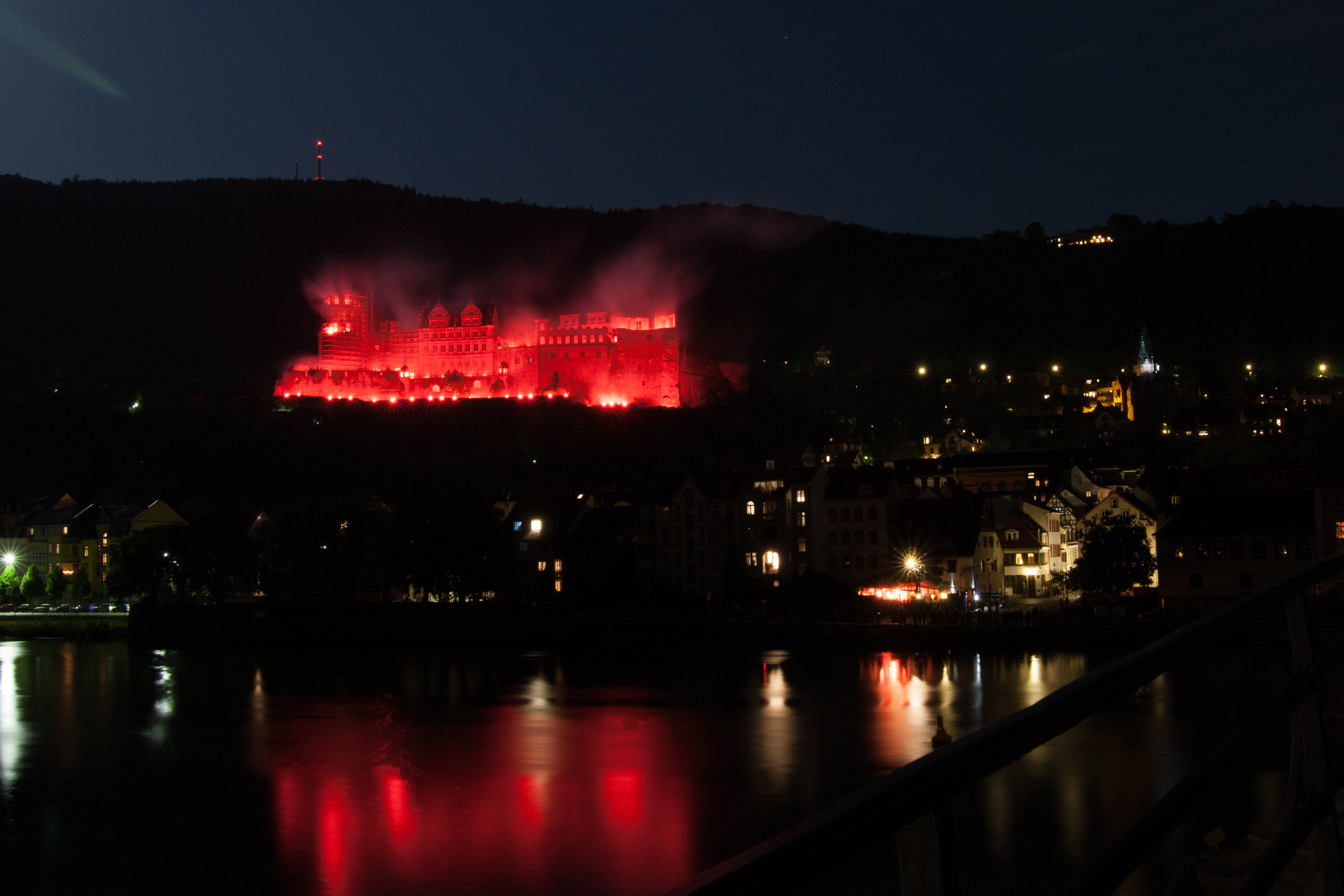 Ruinen des Heidelberger Schloss in rotem Feuerschein. Es wirkt, als würde das Schloss brennen.