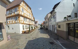 Foto der Hauptstraße in Ladenburg. Links ein Fachwerkhaus.