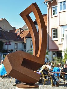 Wiesloch Adenauerplatz – Plastik „Haus mit durchbrochener Form“ (1995) aus Cortenstahl von Werner Pokorny an der Brunnengalerie.