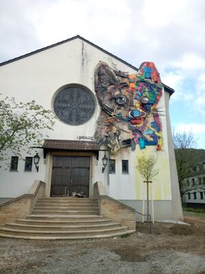 Eingang der Chapel mit Treppe und Kunstwerk in Form eines Hundes.