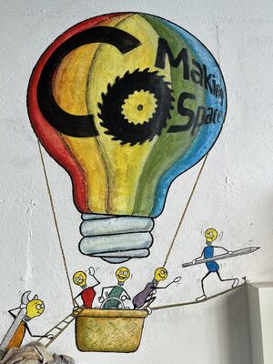 Ein regenbogenfarbener Ballon in Form einer Glühbirne. Kleine Glühbirnenmännchen im Korb. Eines mit Stift und eines mit Schraubenschlüssel steigen ein.